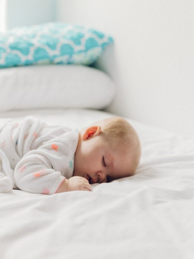 photo of baby laying on bed