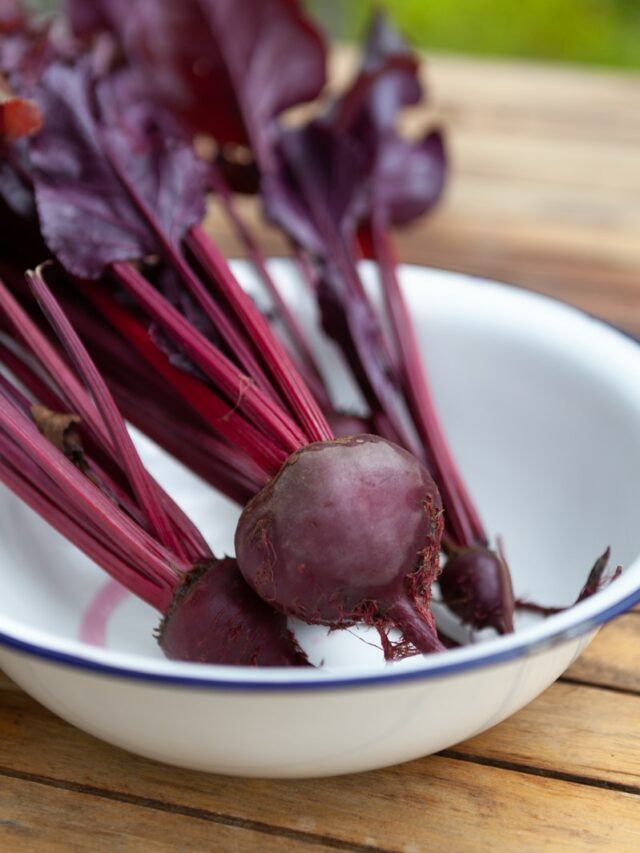 a bowl filled with beets sitting on top of a wooden table