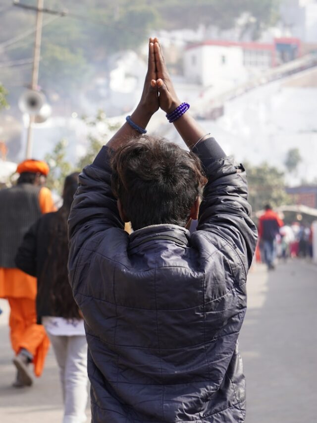 a man standing on a street holding his hands up