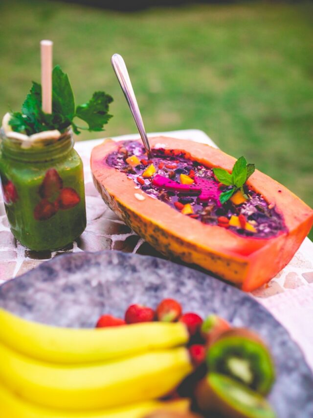 a plate of fruit and a jar of green smoothie